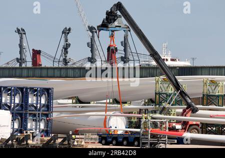 Rostock, Deutschland. 07. Juli 2023. Teile für Windturbinen werden im Überseehafen Rostock gehandhabt. Rostock Port wird seine Halbjahresergebnisse auf einer Pressekonferenz am 07.07.2023 vorstellen. In den ersten sechs Monaten dieses Jahres passierten 15,8 Millionen Tonnen Güter am Kai im Überseehafen von Rostock. Dies ist ein Anstieg von zehn Prozent im Vergleich zum Vorjahr. Die Zahl der beförderten Fährpassagiere stieg um fünf Prozent auf eine Million. Kredit: Bernd Wüstneck/dpa/Alamy Live News Stockfoto