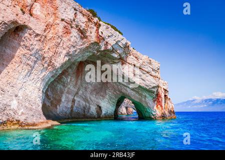 Zakynthos, Griechenland. Felsenbögen der Blauen Höhlen vom Ausflugsboot mit Touristen im blauen Wasser des Ionischen Meeres. Urlaub in Griechenland mit Ausflug Stockfoto