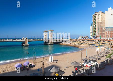 Alexandria, Ägypten - 14. Dezember 2018: Blick auf das Meer von Alexandria mit Stanley Bridge im Hintergrund, normale Leute ruhen am Strand Stockfoto