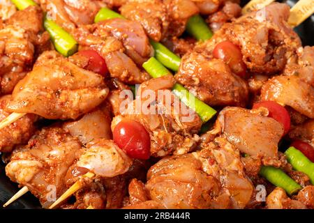 Hühnerspieß. Hähnchenspieße aus der Nähe mit roher Sauce. Lebensmittelhintergrund Stockfoto