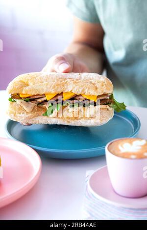 Roast Beef mit Prime Beef Ciabatta Sub Sandwich mit Julienne-Schnitt, serviert in einem Café mit heißem Espresso-Kaffee. Stockfoto