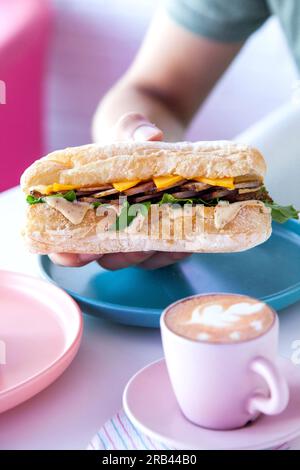 Roast Beef mit Prime Beef Ciabatta Sub Sandwich mit Julienne-Schnitt, serviert in einem Café mit heißem Espresso-Kaffee. Stockfoto