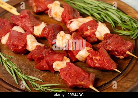 Rinderspieß. Roher Schischkebab auf grauem Hintergrund. Türkische Köstlichkeiten. Lokaler Name dana lokum kusbasi Stockfoto