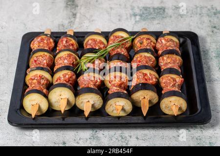 Auberginen-Kebab. Auberginen-Shish-Kebab mit rohem Hackfleisch auf grauem Hintergrund. Türkische Köstlichkeiten. Lokaler Name: Patlican Kebabi Stockfoto