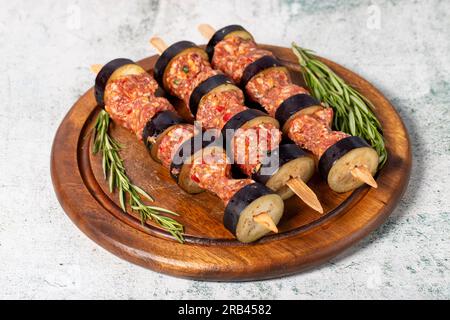 Auberginen-Kebab. Auberginen-Shish-Kebab mit rohem Hackfleisch auf grauem Hintergrund. Türkische Köstlichkeiten. Lokaler Name: Patlican Kebabi Stockfoto