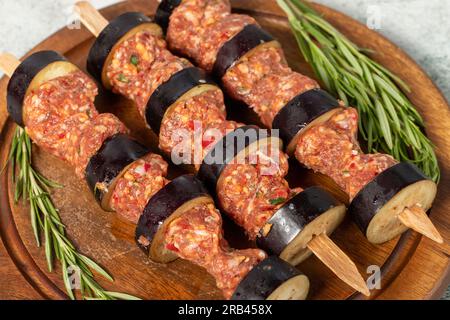 Auberginen-Kebab. Auberginen-Shish-Kebab mit rohem Hackfleisch auf grauem Hintergrund. Türkische Köstlichkeiten. Lokaler Name: Patlican Kebabi Stockfoto