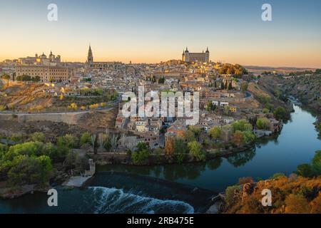 Skyline von Toledo mit Kathedrale, Alcazar und Fluss Tejo bei Sonnenuntergang - Toledo, Spanien Stockfoto