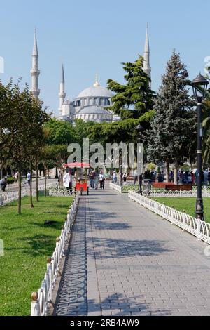 Sultan Ahmed aka Blaue Moschee in der Gegend von Sultanahmet. Simits, auch bekannt als türkische Bagels, werden von einem roten Verkaufswagen in den Gärten verkauft. Istanbul, Türkei Stockfoto