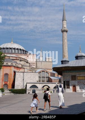 Muslimische Frau mit Kindern geht vor der Hagia Sophia Moschee und dem Sultan Ahmed III Brunnen, Istanbul, Türkei Stockfoto