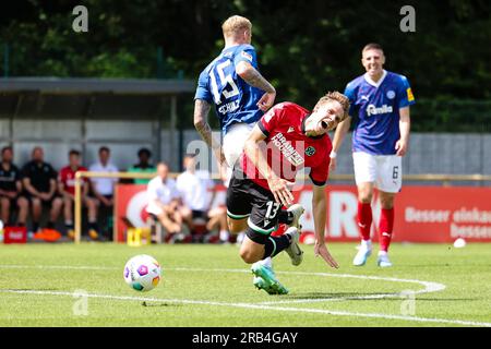 Kiel, Deutschland. 07. Juli 2023. Fußball: Testspiele, Holstein Kiel - Hannover 96. Kieles Marvin Schulz (l) erschüttert Hannovers Max Christiansen. Kredit: Frank Molter/dpa/Alamy Live News Stockfoto