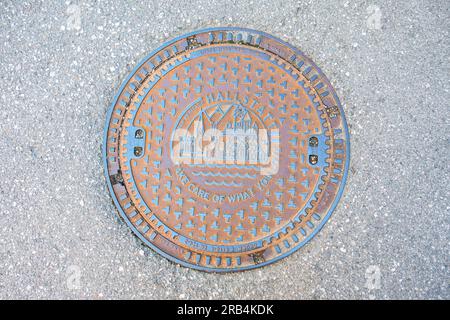 Straße, Kanaldeckel auf einer Straße, Hallstatt, PASS AUF, WAS DU LIEBST, RHV HALLSTATTERSEE GEWASSERSCHUTZ im WELTERBE, WASSERSCHUTZ IN DER WELT SIE Stockfoto