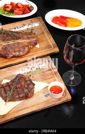 Mittelgeröstetes Steak, auf einem Holzbrett in Stücke geschnitten. Stockfoto