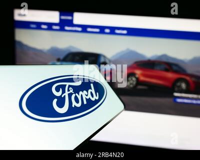 Smartphone mit Logo des amerikanischen Automobilherstellers Ford Motor Company auf dem Bildschirm vor der Website. Fokus auf die Mitte links des Telefondisplays. Stockfoto