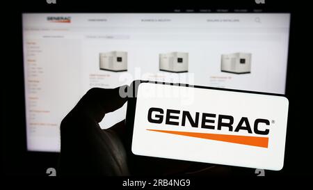 Person, die ein Mobiltelefon mit dem Logo der US-amerikanischen Firma Generac Holdings Inc. Auf dem Bildschirm vor der Unternehmenswebseite hält. Konzentrieren Sie sich auf das Display des Telefons. Stockfoto