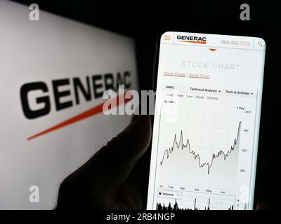 Person, die ein Mobiltelefon mit einer Website der US-amerikanischen Firma Generac Holdings Inc. Auf dem Bildschirm vor dem Unternehmenslogo hält. Konzentrieren Sie sich auf die Mitte des Telefondisplays. Stockfoto