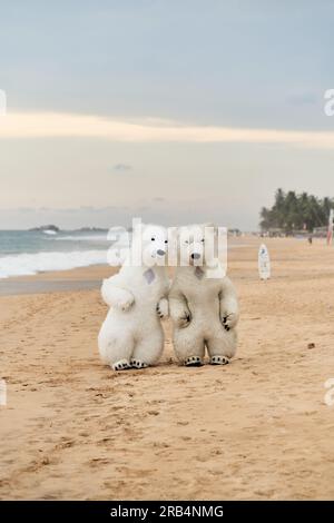 Animateure, die als Eisbären verkleidet sind, unterhalten die Leute am Strand Stockfoto