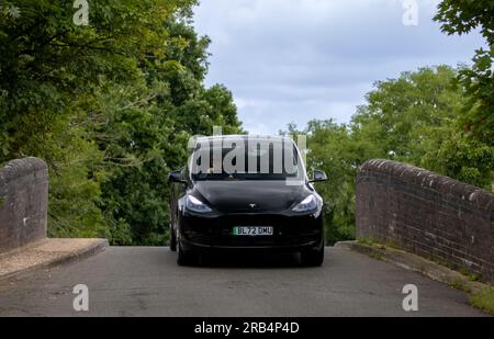 Milton Keynes, Großbritannien - Juli 6. 2023: 2022 TESLA, MODELL Y, ELEKTROFAHRZEUG MIT GROSSER REICHWEITE und Allradantrieb auf einer schmalen Buckelbrücke Stockfoto