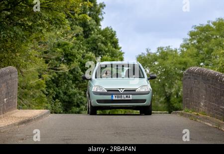 Milton Keynes, UK - Juli 6. 2023: 2001 hellgrüner VAUXHALL CORSA-Wagen auf einer schmalen, Buckelbrücke Stockfoto