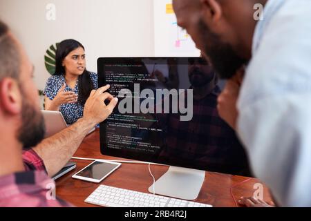 Zwei Entwickler programmieren gemeinsam im Büro, um Peer Reviews zu unterstützen Stockfoto