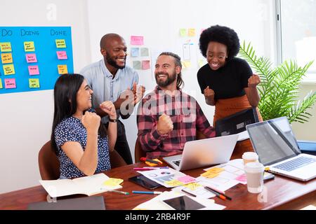 Eine Gruppe von Entwicklern feiert die erfolgreiche Einführung der neuen mobilen App im Büro Stockfoto