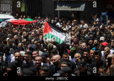 Nablus, Palästina. 07. Juli 2023. Die Trauernden marschieren mit der palästinensischen Flagge während der Beerdigung zweier Palästinenser, die von israelischen Spezialeinheiten im nördlichen Westjordanland getötet wurden. Eine israelische Spezialeinheit infiltrierte die Altstadt von Nablus und tötete zwei palästinensische Schützen. Die Spezialeinheit zog sich zurück, nachdem die israelische Armee kam und das Gebiet sicherstellte. (Foto von Nasser Ishtayeh/SOPA Images/Sipa USA) Guthaben: SIPA USA/Alamy Live News Stockfoto