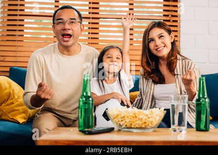 Glückliche Familie, die sich gemeinsam ein Sportspiel im Fernsehen ansieht Stockfoto