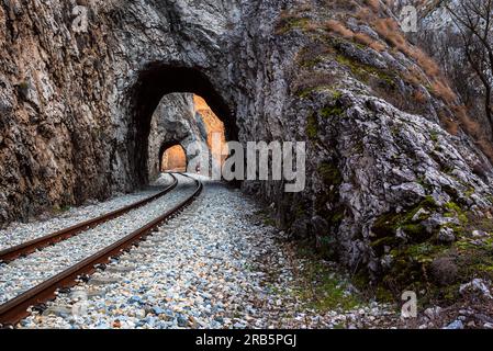 Alte Eisenbahn durch kurze Tunnel in malerischer ländlicher Landschaft Stockfoto