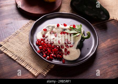 Chiles en Nogada, typisches Gericht aus Mexiko. Zubereitet mit Poblano-Chili gefüllt mit Fleisch und Obst und mit einer Walnusssoße überzogen. Benannt als die Qui Stockfoto