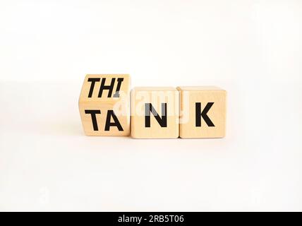 Denkfabriksymbol. Ein Geschäftsmann dreht Holzwürfel um und ändert das Wort „Tank“, um zu denken, oder umgekehrt. Wunderschöner weißer Tischhintergrund, Kopierbereich Stockfoto