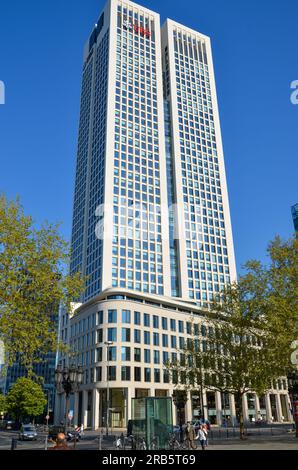 Frankfurt am Main, Deutschland: 19. April 2011: Opernturm oder UBS-Bankgebäude in Frankfurt unter blauem Himmel mit einigen Bäumen im Vordergrund Stockfoto