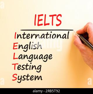 IELTS-Symbol. Konzeptbegriffe IELTS Testsystem in internationaler englischer Sprache auf dem Whitepaper. Wunderschöner brauner Hintergrund. Business IELTS Internation Stockfoto