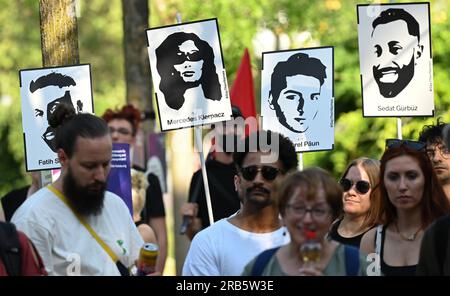 07. Juli 2023, Hesse, Wiesbaden: Bilder der Opfer des Hanau-Angriffs werden während einer Kundgebung auf dem Gelände von Dern aufgehalten. Unter dem Motto „Keine Gerechtigkeit ohne Konsequenzen!“ In der Initiative vom 19. Februar hatte Hanau eine Demonstration gefordert. Ein 43-jähriger Deutscher hatte am 19. Februar 2020 neun Menschen in Hanau erschossen, aus rassistischen Motiven. Dann tötete er seine Mutter und sich selbst. Seit dem Sommer 2021 beschäftigen sich die Mitglieder des staatsparlaments im Untersuchungsausschuss mit dem Angriff. Foto: Arne Dedert/dpa - ACHTUNG: Nur zur redaktionellen Verwendung und nur mit vollständiger Erwähnung der oben genannten Punkte Stockfoto