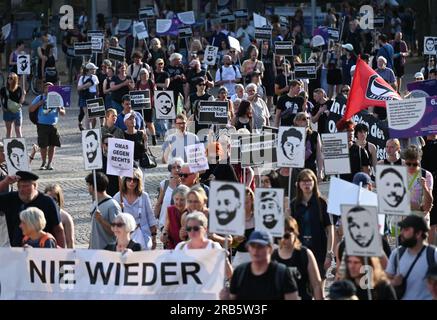 07. Juli 2023, Hessen, Wiesbaden: Teilnehmer einer Demonstration halten nach einer Kundgebung für die Opfer des Anschlags in Hanau Poster mit Bildern der Opfer. Unter dem Motto „Keine Gerechtigkeit ohne Konsequenzen!“ In der Initiative vom 19. Februar hatte Hanau eine Demonstration gefordert. Ein 43-jähriger Deutscher hatte am 19. Februar 2020 in Hanau neun Menschen aus rassistischen Motiven erschossen. Dann tötete er seine Mutter und sich selbst. Seit dem Sommer 2021 beschäftigen sich die Mitglieder des staatsparlaments im Untersuchungsausschuss mit dem Angriff. Foto: Arne Dedert/dpa - ACHTUNG: Nur zur redaktionellen Verwendung und nur mit Stockfoto