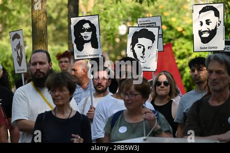 07. Juli 2023, Hesse, Wiesbaden: Bilder der Opfer des Hanau-Angriffs werden während einer Kundgebung auf dem Gelände von Dern aufgehalten. Unter dem Motto „Keine Gerechtigkeit ohne Konsequenzen!“ In der Initiative vom 19. Februar hatte Hanau eine Demonstration gefordert. Ein 43-jähriger Deutscher hatte am 19. Februar 2020 neun Menschen in Hanau erschossen, aus rassistischen Motiven. Dann tötete er seine Mutter und sich selbst. Seit dem Sommer 2021 beschäftigen sich die Mitglieder des staatsparlaments im Untersuchungsausschuss mit dem Angriff. Foto: Arne Dedert/dpa - ACHTUNG: Nur zur redaktionellen Verwendung und nur mit vollständiger Erwähnung der oben genannten Punkte Stockfoto