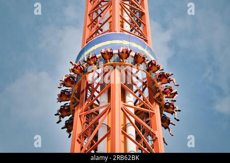 Leute fallen vom Turmritt im Vergnügungspark. Berühmte Attraktion Free Fall Tower im Vergnügungspark Stockfoto