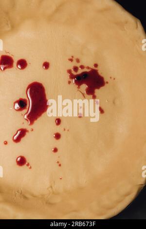 Rote Tropfen brombeersaft auf rohem Teigkruste Spritzer Stockfoto