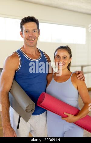 Portrait eines glücklichen weißhäutigen Paares, das Matten umarmt und hält. Gesunder Lebensstil, Wohlbefinden, Yoga, Beziehung, Zusammensein, Fitness und e Stockfoto