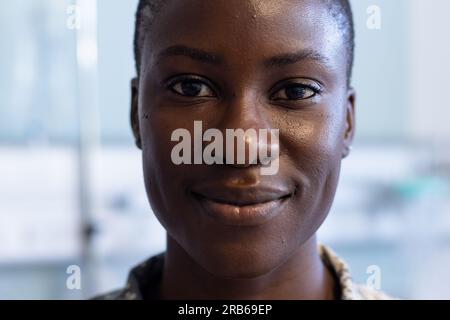 Porträt einer glücklichen afroamerikanischen Soldatin in Militäruniform, die im Krankenhaus lächelt. Krankenhaus, Medizin, Gesundheitswesen, Gesundheitsdienstleistungen und Stockfoto