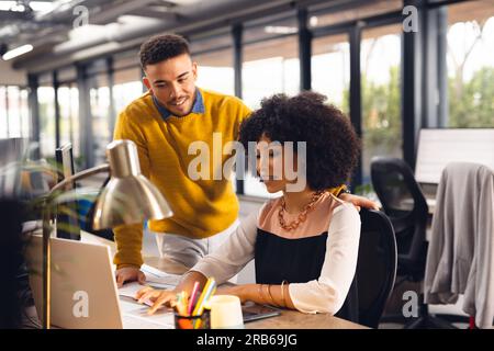 Verschiedene Geschäftsleute diskutieren im Büro über Arbeit und die Verwendung von Laptops. Business, Teamwork, Kommunikation und Arbeit. Stockfoto