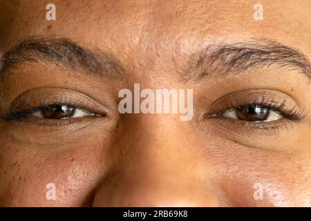 Nahaufnahme der Augen eines birassischen, lockeren Geschäftsmanns, der lächelt. Arbeit, Geschäft, Selbstvertrauen, Wohlbefinden und ungezwungenes Büro, unverändert. Stockfoto