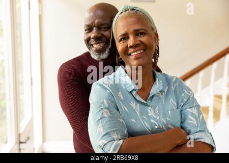 Portrait eines glücklichen, hochrangigen afroamerikanischen Paares, das im Flur lächelt und umarmt. Seniorenleben, Glück, Ruhestand und häusliches Leben, unaltere Stockfoto