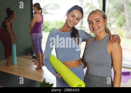 Porträt glücklicher Weißer, die im Yoga-Unterricht eine Matte halten. Yoga, Bewegung, Fitness und gesunder Lebensstil, unverändert. Stockfoto