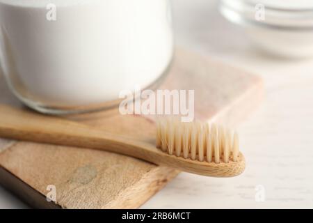 Bambuszahnbürste und Backpulver auf weißem Tisch, Nahaufnahme Stockfoto