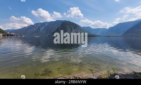 Hallstatt-See in Hallstatt, eine kleine Stadt im Stadtteil Gmunden, Österreich, mit Berg- und blauen Wolken im Hintergrund. Stockfoto