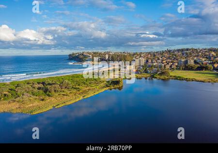 Luftdrohnenaufnahme von einem Strand und Lagunensee während der goldenen Stunde in Sydney, Australien Stockfoto