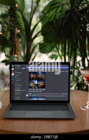 Odessa, Ukraine - 14. Juni 2023: Mithilfe der Midjourney- und Discord-Website visuelle Inhalte auf Laptops im Café generieren. Stockfoto