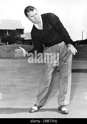 New Jersey: ca. 1953 Ein Mann, der mit einer anderen Sportausrüstung posiert und Ähnlichkeiten mit der Körperhaltung zeigt. Hier benutzt er einen Handballhandschuh. Stockfoto