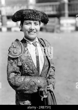 Lima, Peru: ca. 1931 Eine lächelnde junge Stierkämpferin, die eine goldene und silberne Jacke im Stierkampf trägt. Stockfoto