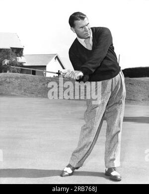 New Jersey: ca. 1953 Ein Mann, der mit einer anderen Sportausrüstung posiert und Ähnlichkeiten mit der Körperhaltung zeigt. Hier benutzt er einen Golfschläger. Stockfoto