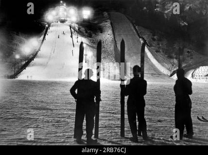 Germisch, Deutschland: 2. Februar 1937. Das Winterstadion in Garmisch, Deutschland, Austragungsort der Olympischen Winterspiele 1936, wird nachts für einen Skisprung beleuchtet. Stockfoto